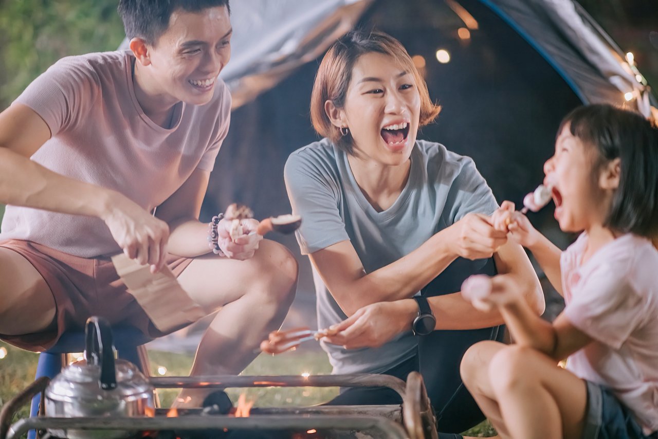 Asian chinese family with daughter enjoying BBQ grill camping at backyard of their house staycation weekend activities