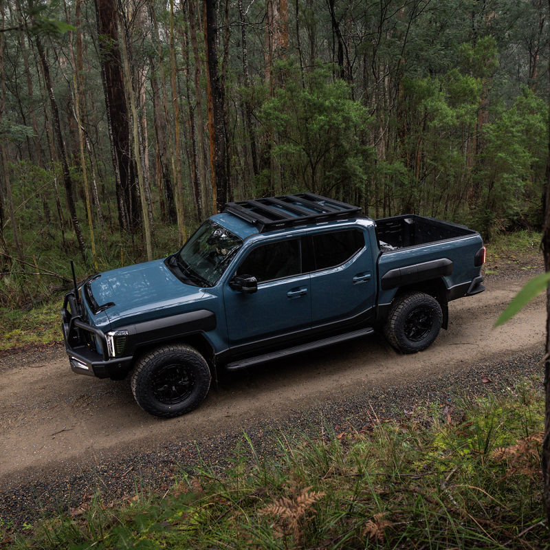 Kia Tasman in the woods.