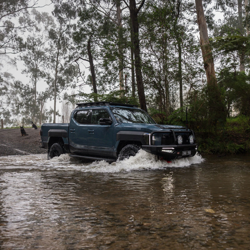 Blue Kia Tasman Crossing River