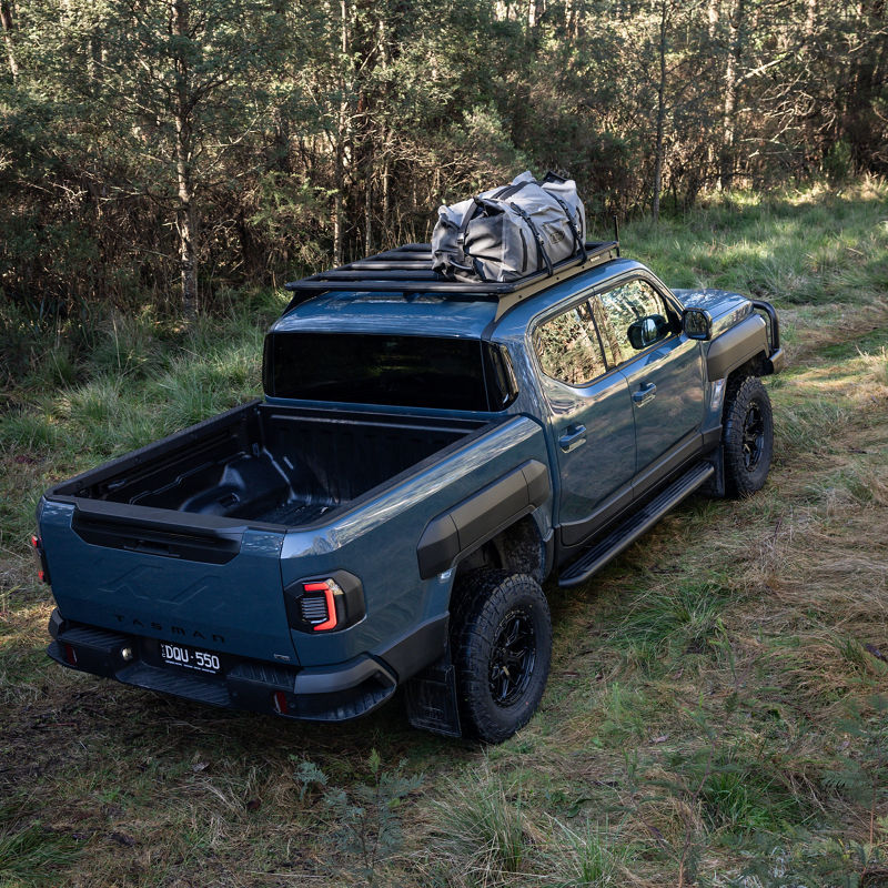 Back of a Blue Kia Tasman showing an ARB BASE Rack.