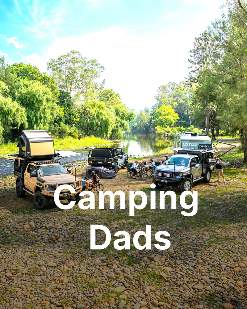 ARB equipped Ford Ranger Super Duty vehicles and camper trailers set up at a riverside campsite.