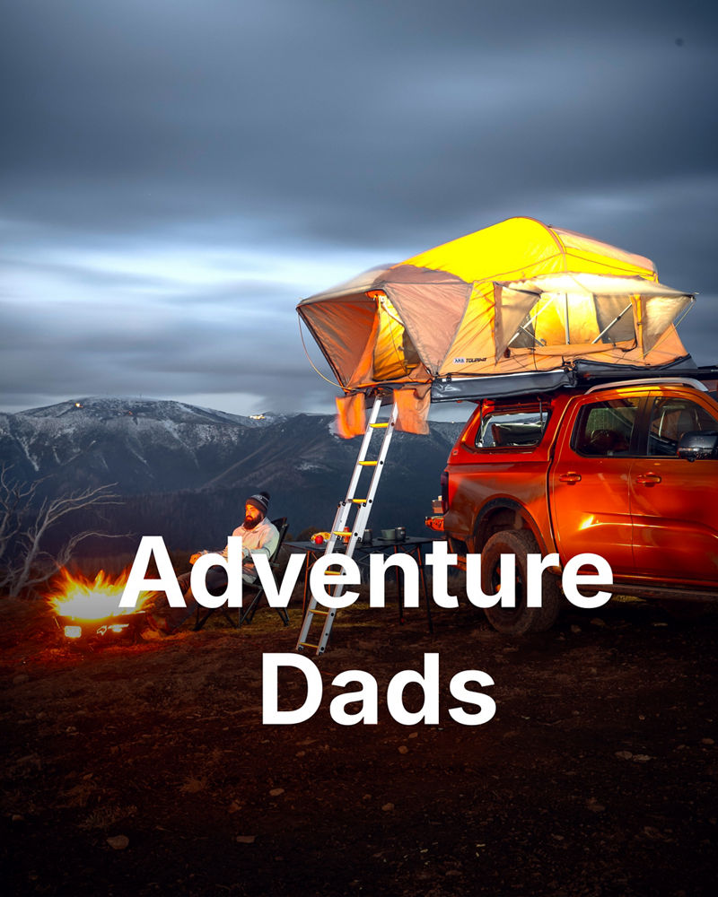 ARB equipped dual cab ute with a rooftop tent at a mountain campsite beside a campfire.
