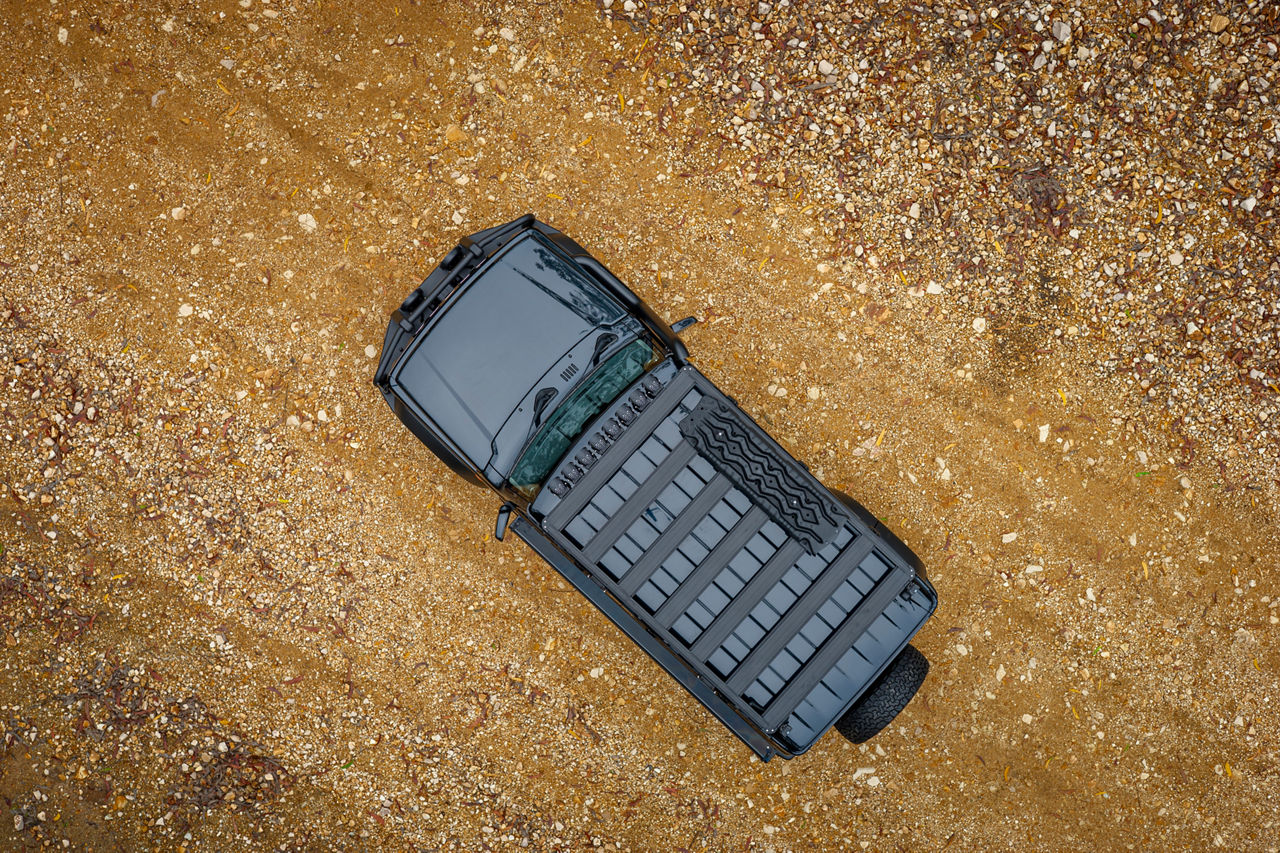 Aerial view of an ARB BASE Rack fitted to a Suzuki Jimny on a gravel surface.