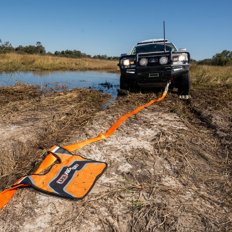 ARB recovery strap and recovery damper connected to an ARB equipped 4WD during a vehicle recovery in muddy terrain.