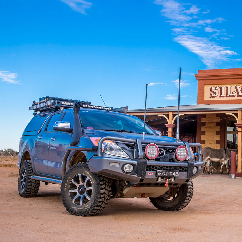 ARB equipped Mazda BT-50 parked in front of the Silverton Hotel with a canopy, roof rack system and driving lights.