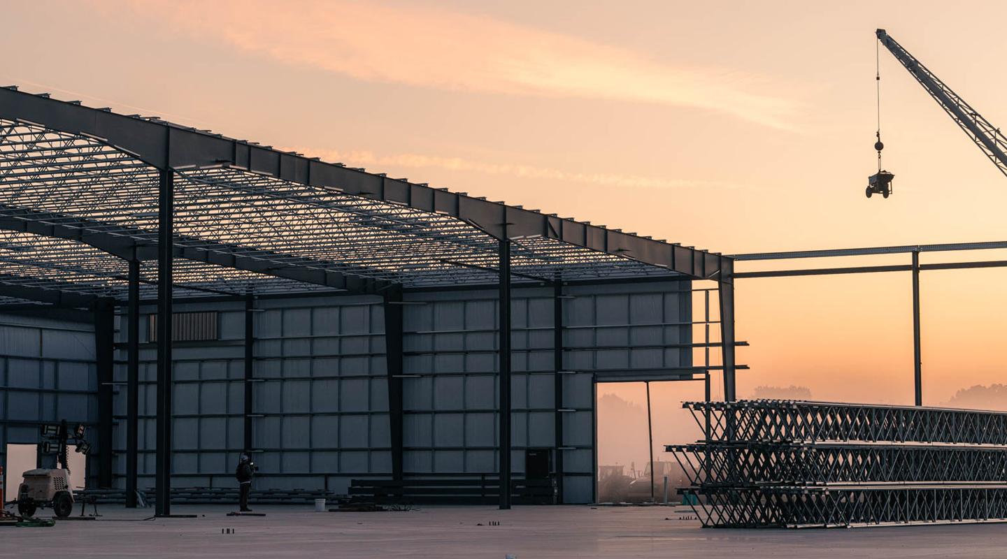 Pre-engineered metal building construction site at dusk. 