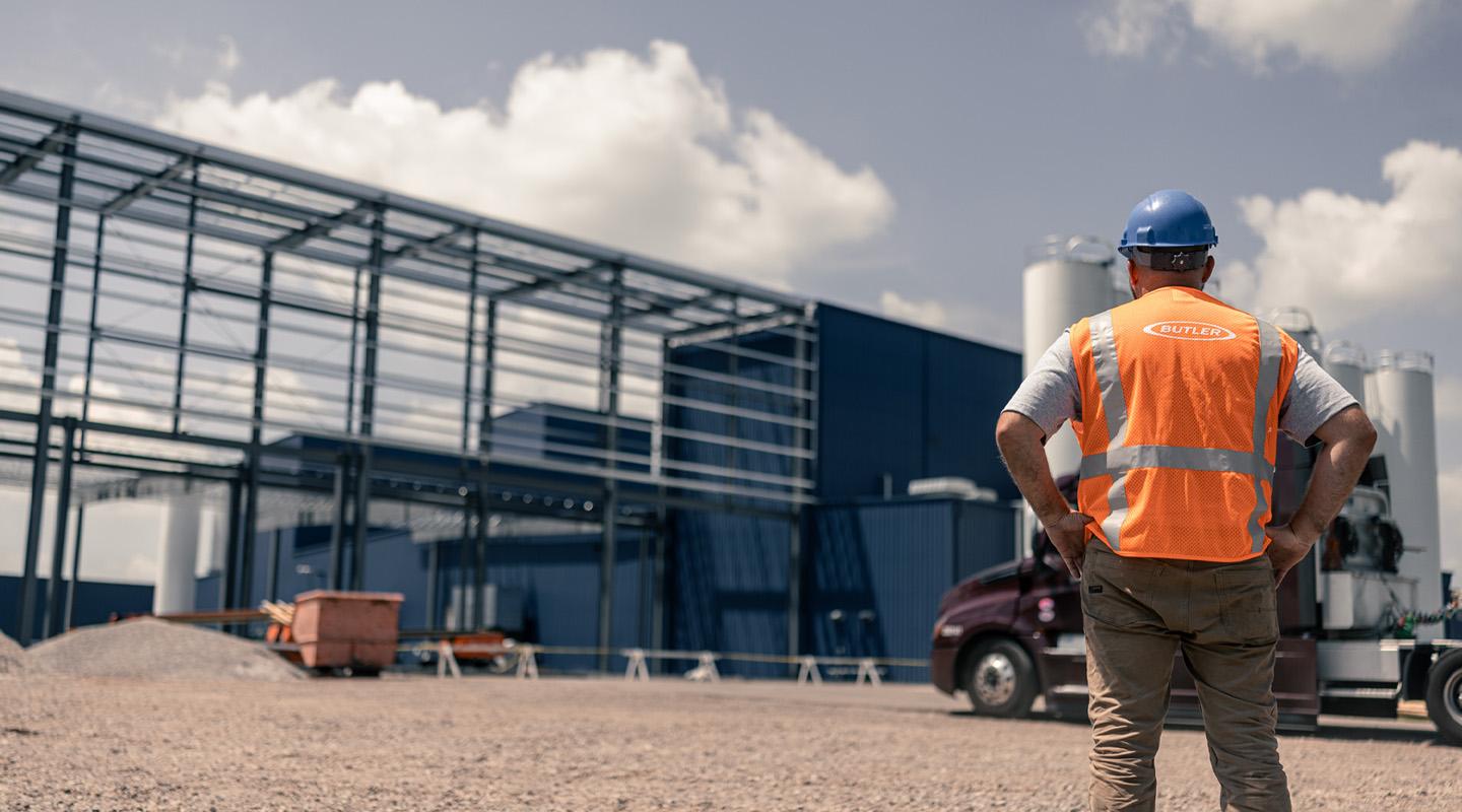 Construction worker observing exposed steel frame building 