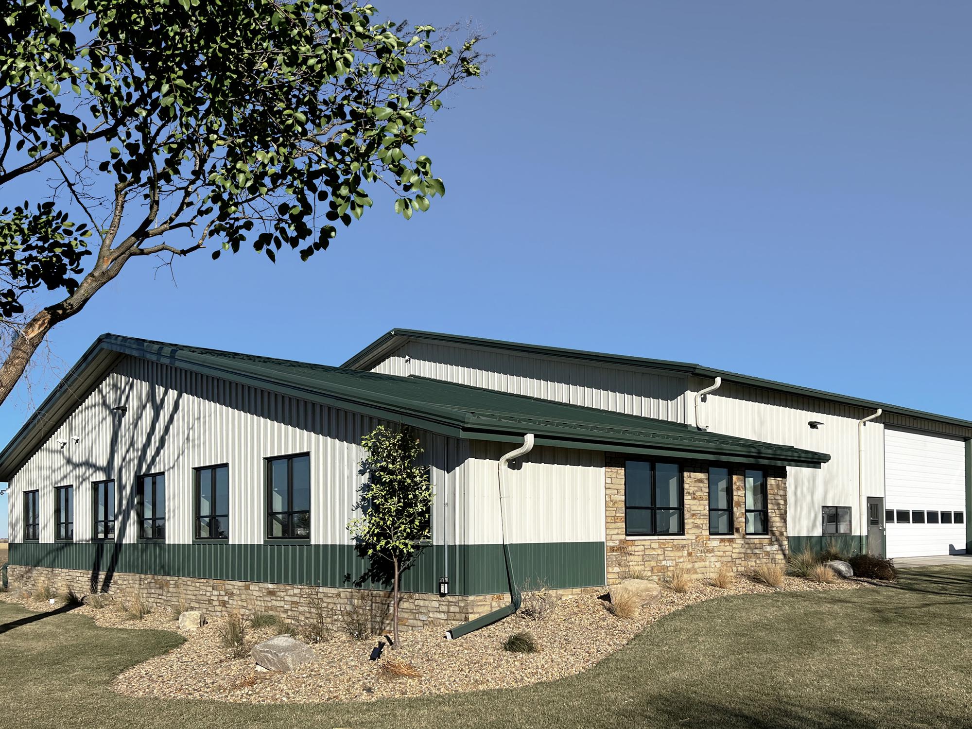 Metal building exterior featuring insulated wall panels, stone accents and overhead garage door access