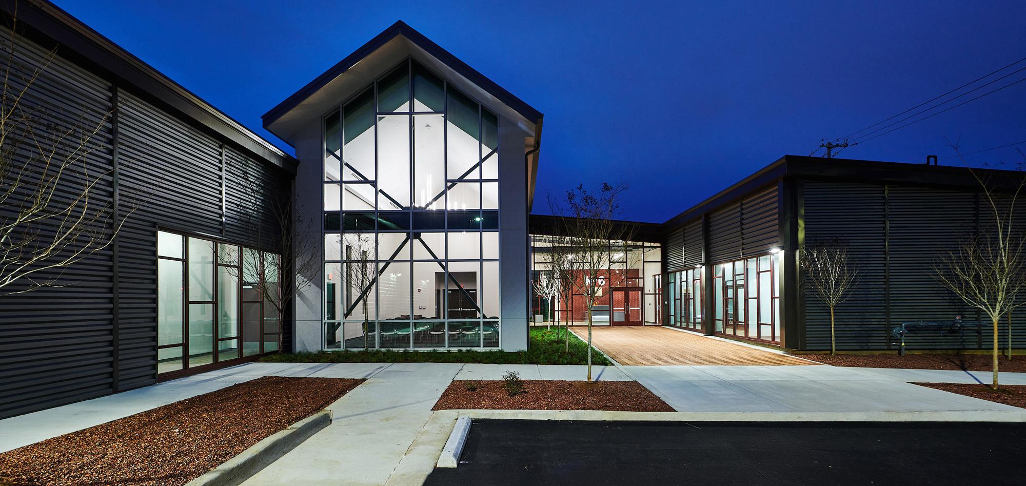 Exterior evening view of the Firehouse Shelter – New Facility featuring welcoming community-centered design, integrated support spaces and a resilient facility developed to provide essential services within a constrained urban site.