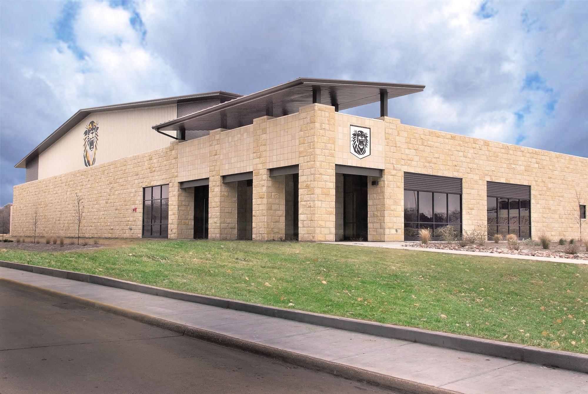 Exterior view of the Fort Hays State University Indoor Practice Facility featuring stone facade and integrated campus architectural design.