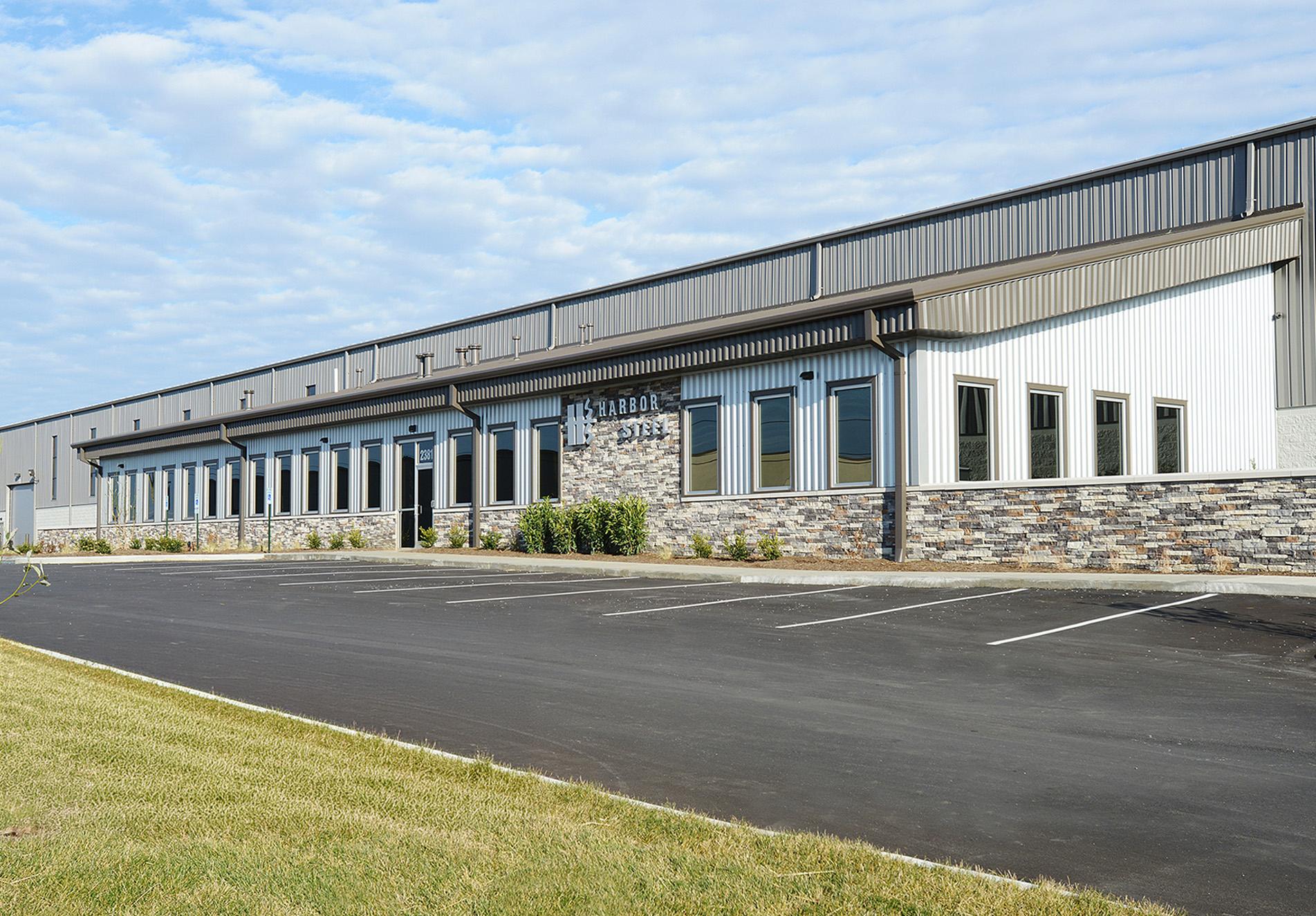 Exterior view of the Harbor Steel facility featuring integrated office space, stone accents and metal wall panel systems.