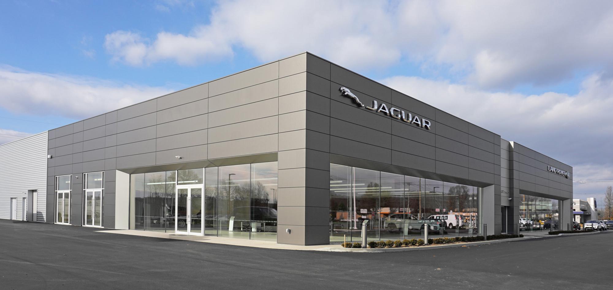 Exterior view of the Jaguar Land Rover dealership featuring expansive showroom glazing, integrated service operations and a large-span automotive facility designed to support brand standards, customer visibility and operational efficiency.
