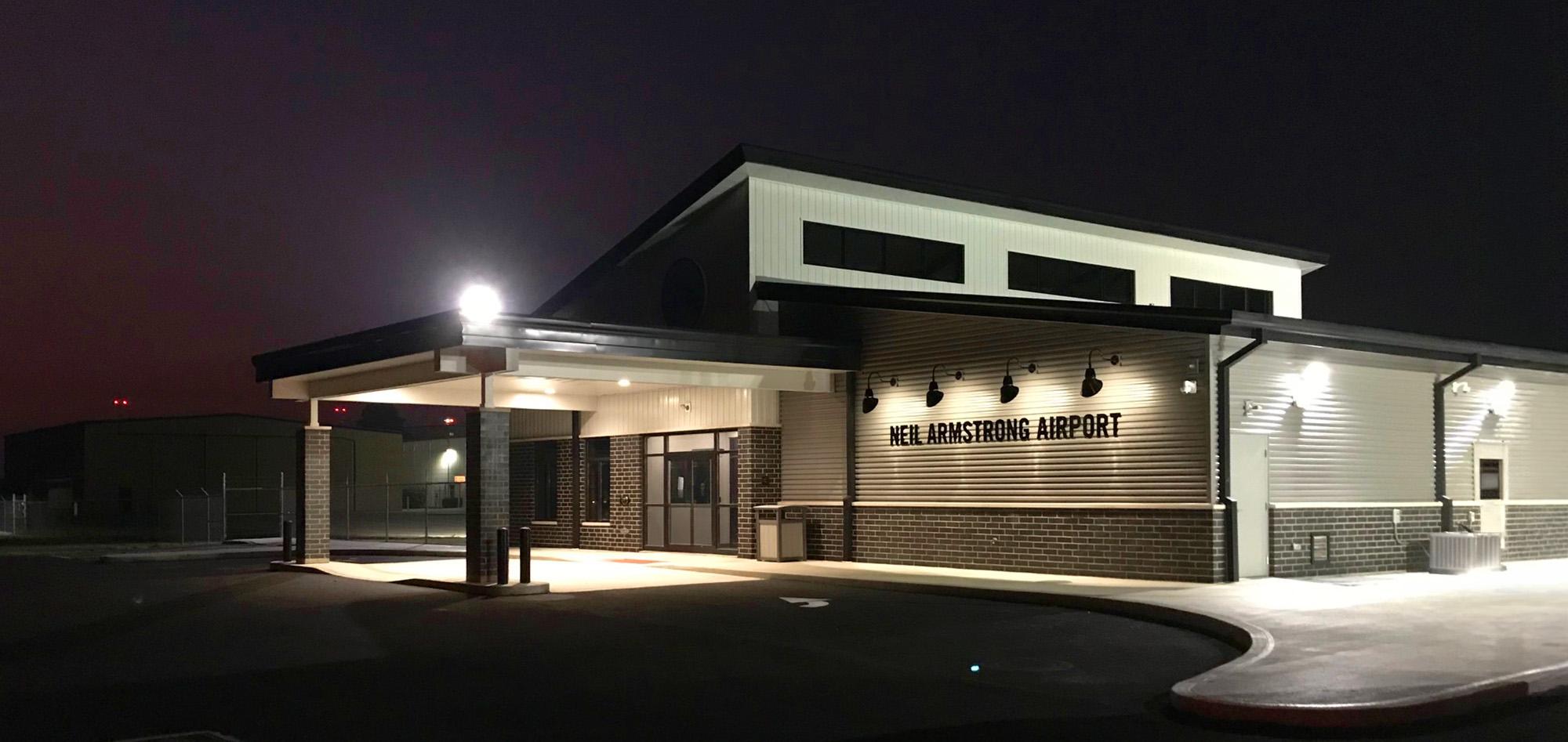 Neil Armstrong airport terminal featuring architectural metal wall panels, covered passenger drop-off area and aviation facility construction.