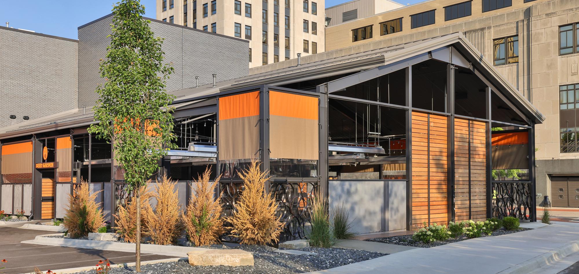 Exterior view of the New Holland Brewing Co. beer garden featuring integrated covered outdoor gathering space, coordinated urban design and a flexible hospitality environment developed for year-round dining, entertainment and community engagement.