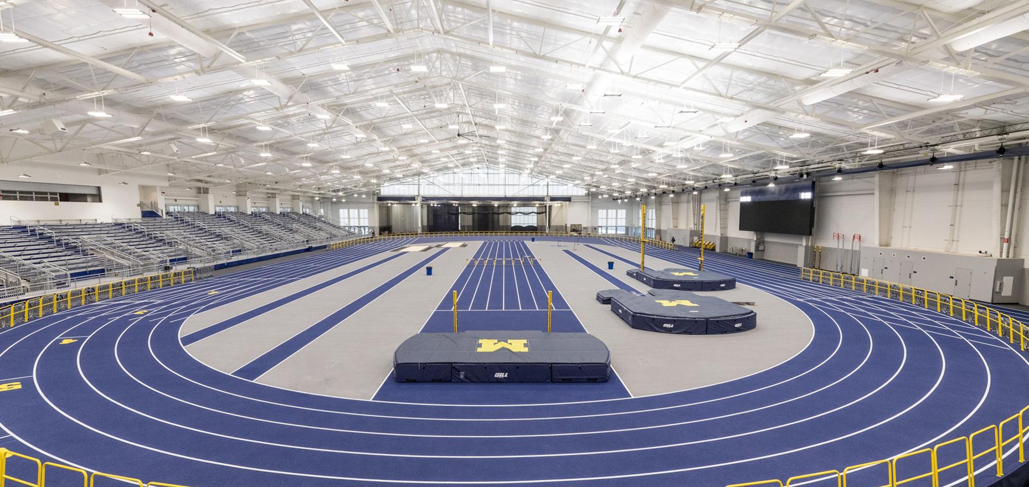 Interior view of the University of Michigan Indoor Track Facility featuring an advanced competition track, integrated training environments and coordinated spectator infrastructure designed to support elite athletic performance and large-scale events.