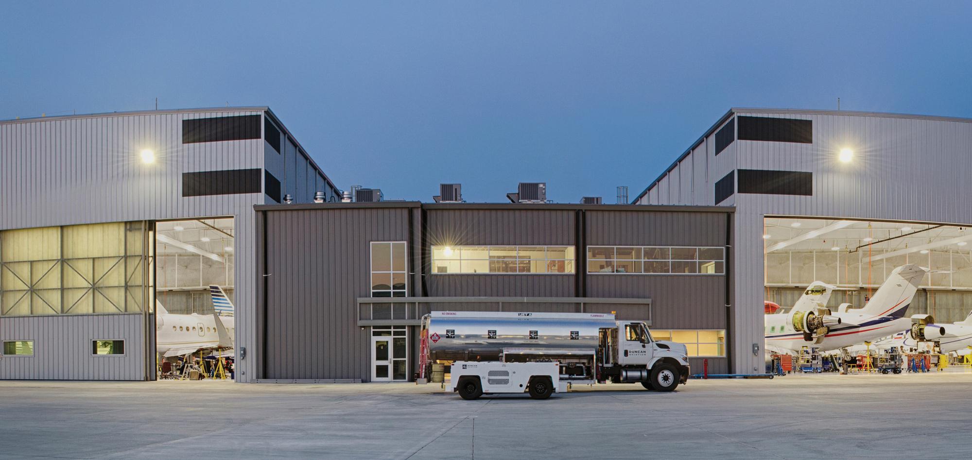 Exterior evening view of the Duncan Aviation Lincoln Maintenance Hangar featuring high-clearance aircraft service bays, integrated maintenance operations and coordinated aviation support spaces designed to accommodate larger aircraft and growing operational demand.