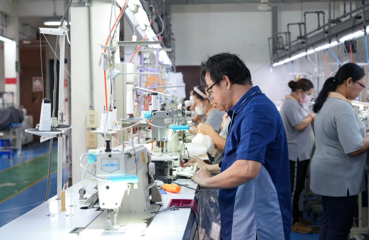 textile factory with workers and work stations in the foreground