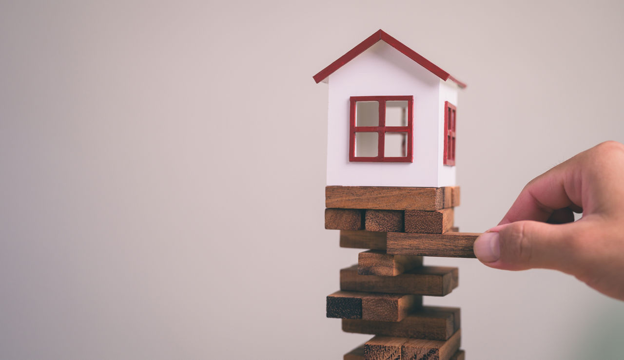 abstract representation using a model house on jenga blocks