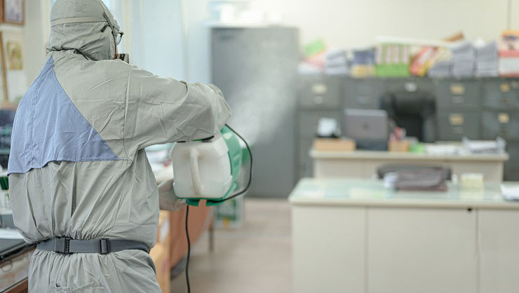 Disinfecting of office to prevent COVID-19, person in white hazmat suit with disinfect in office, Disinfectant worker wear protective mask and suit sprays coronavirus.