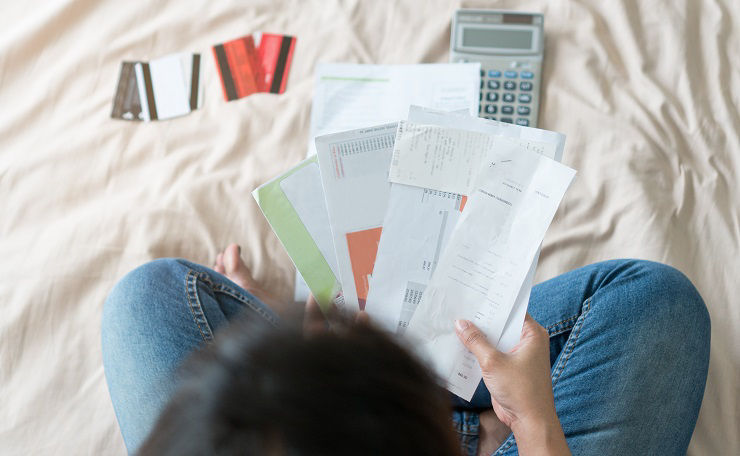 Top view of stressed young asian woman trying to find money to pay credit card debt.