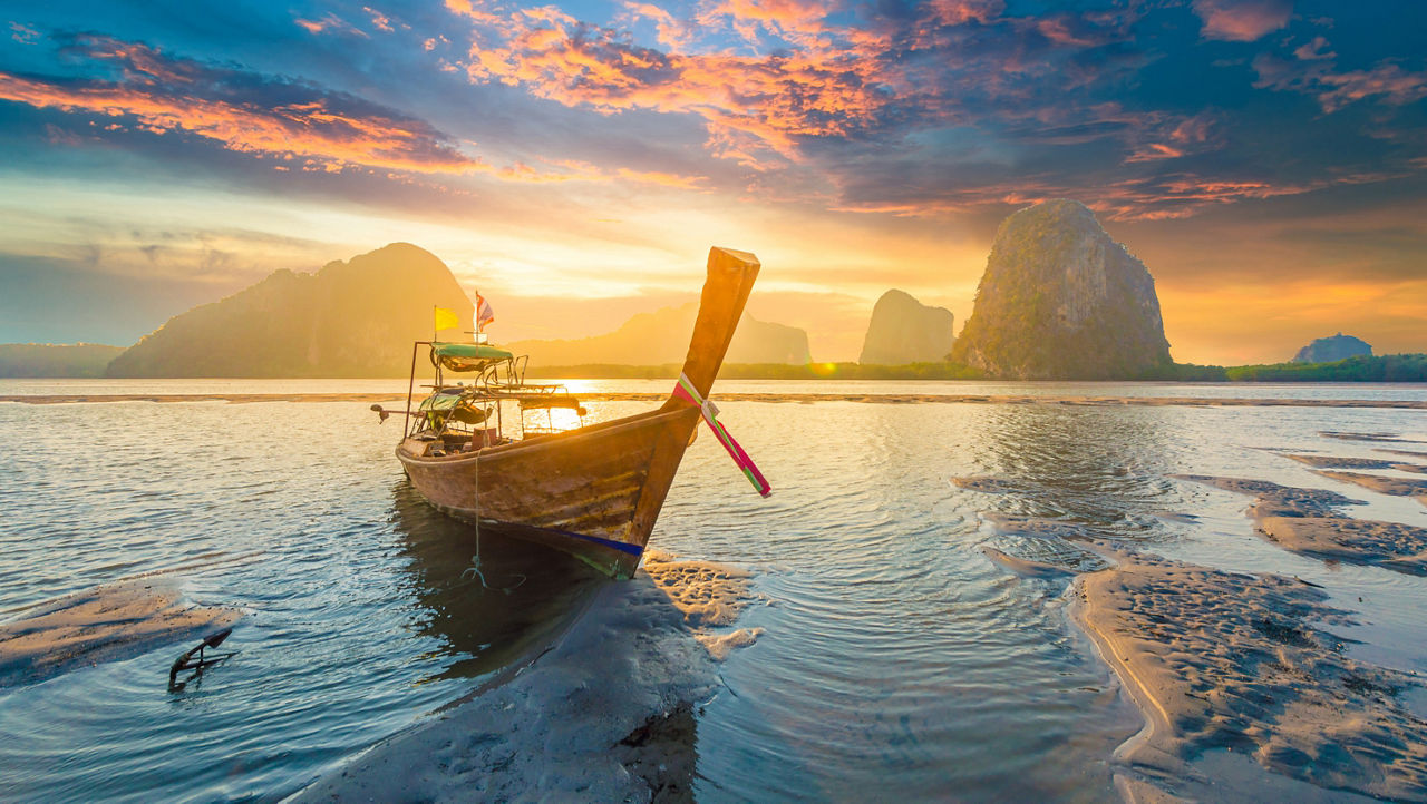 Beautiful sunset at tropical sea with long tail boat in south thailand