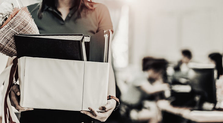 Business woman carrying packing up all his personal belongings and files into a white cardboard box to resignation in modern office, resign concept