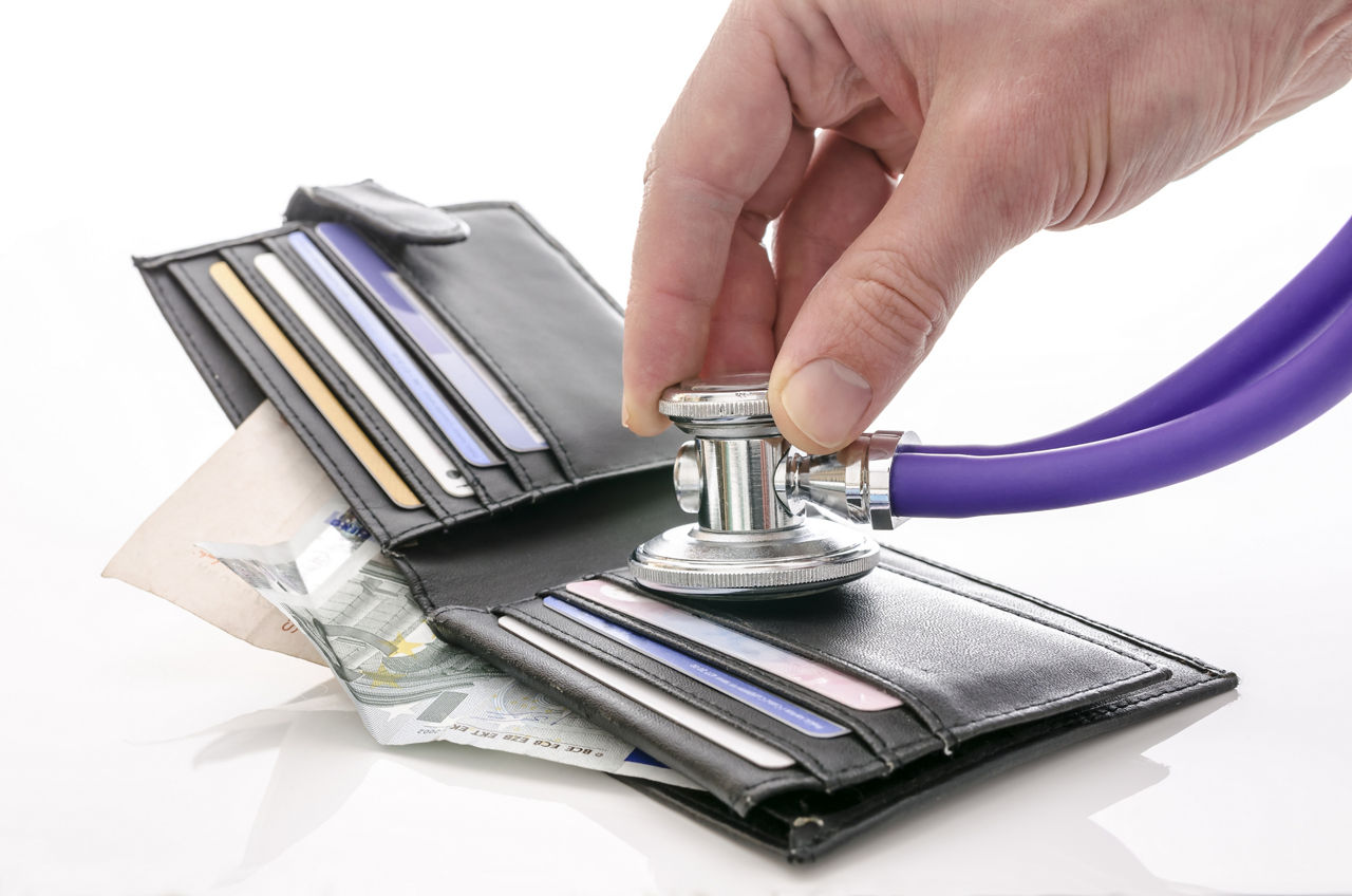 Checking open wallet with stethoscope. Concept of financial crisis.