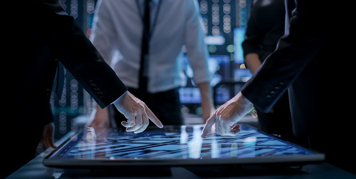 Corporate Managers Working at the Table in Monitoring Room. Room is Full of State of the Art Technology. Computers with Animated Screens.; Shutterstock ID 669170812; purchase_order: BOT; job: ; client: ; other: 