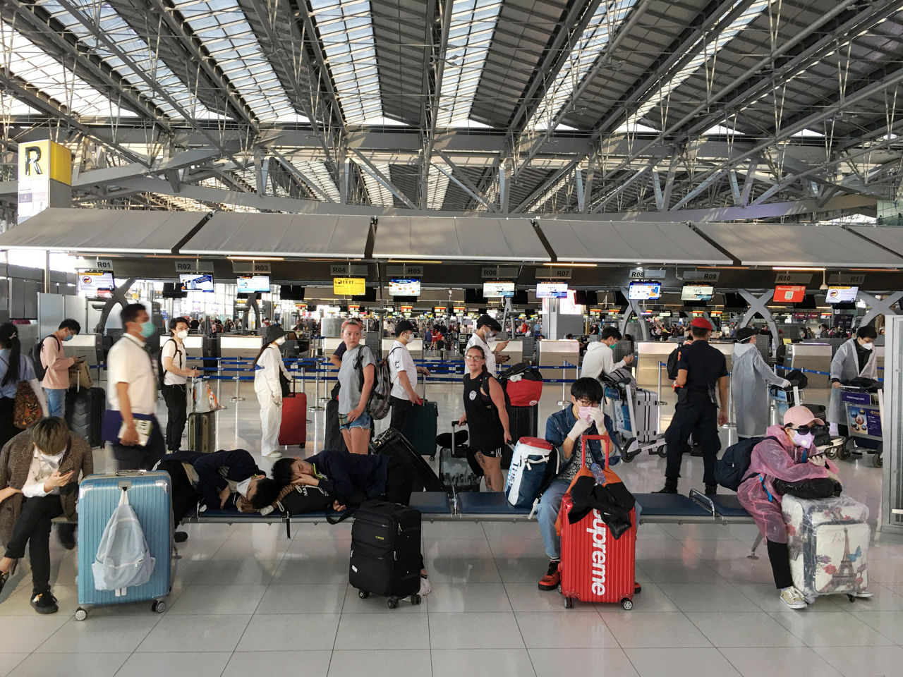 Bangkok, Thailand - March 24, 2020: Travelers Getting Ready To Depart From The Airport With Their Suitcases And Wearing Protective Clothing During The Coronavirus Epidemic