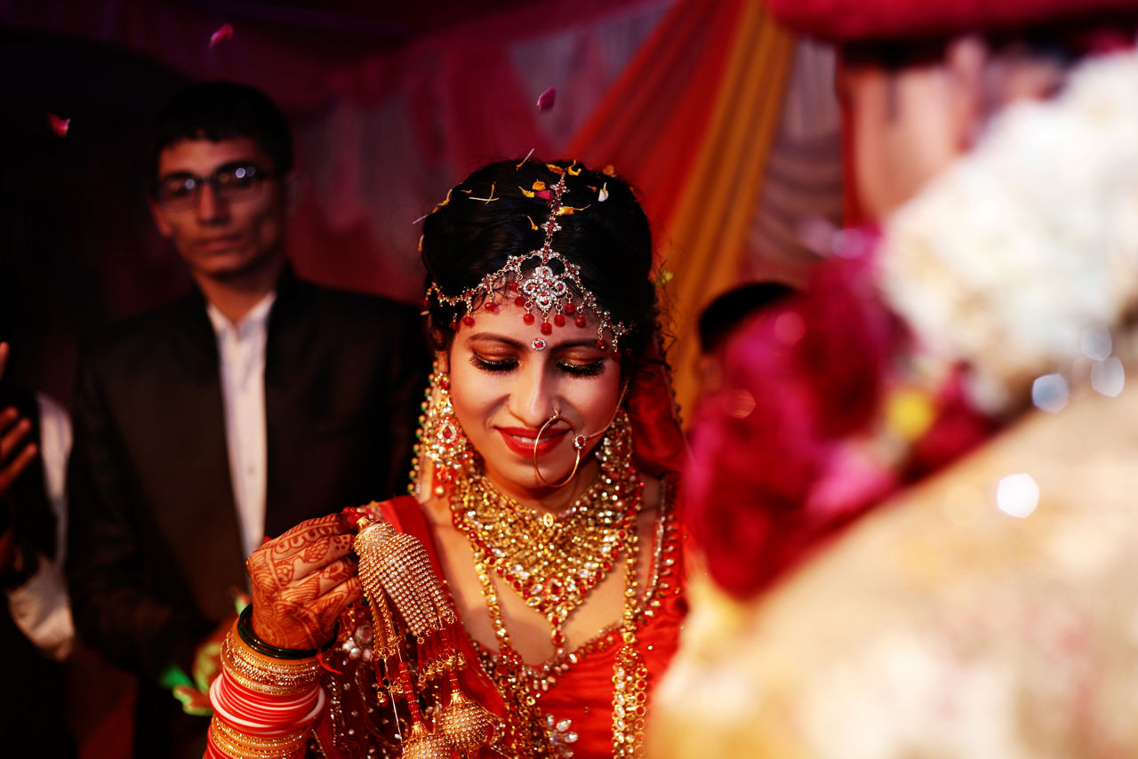 The bride and groom at the Indian wedding garlands or Jaimala ceremony on the stage.