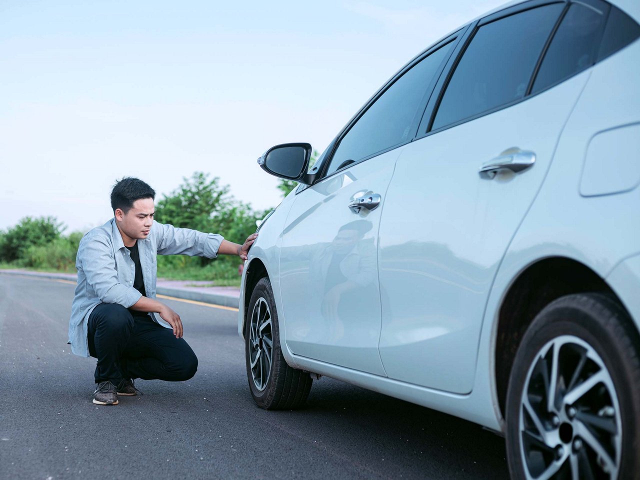 A car owner inspects his car.