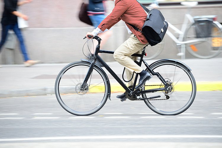 Man in suit on bike in profile