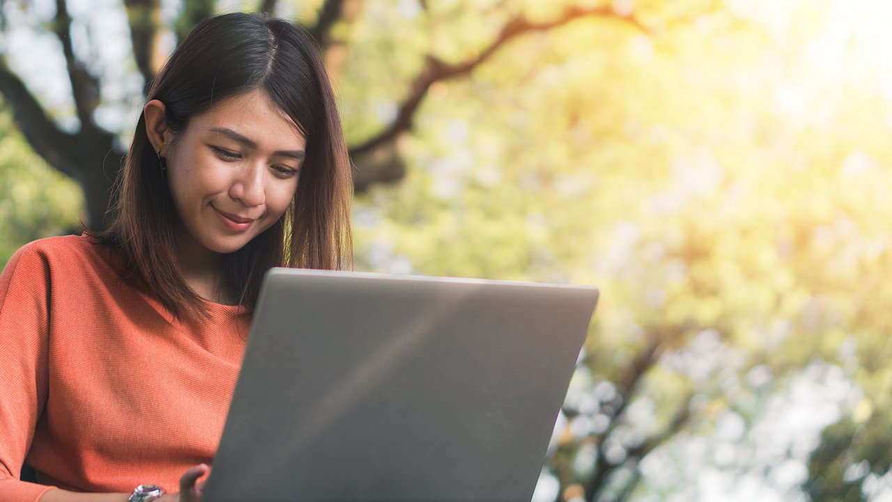 Woman looking at a laptop in the park