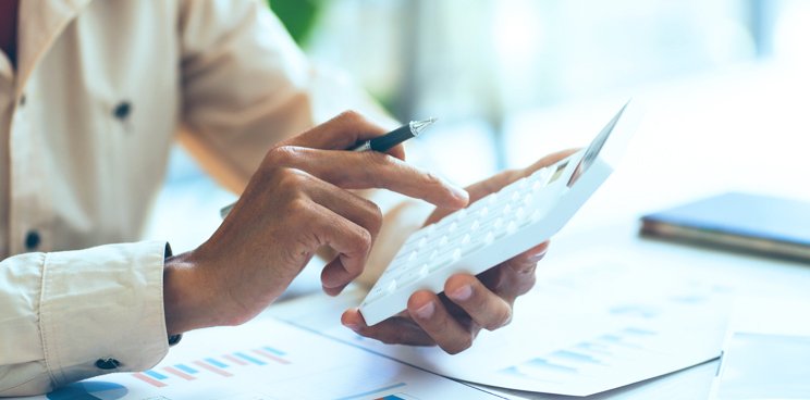 A person with graphs and calculating earnings from investments