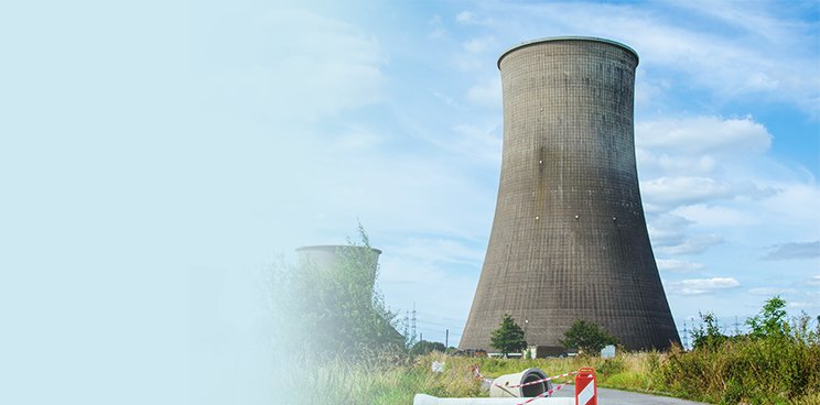 Smoke coming out of a coal plant with a blue sky backdrop