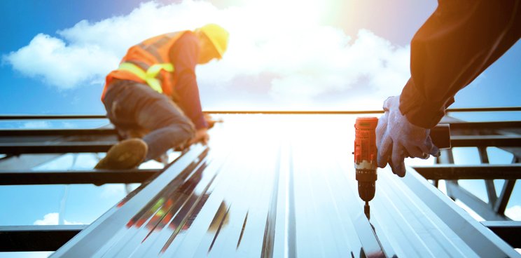 Two construction workers working on a roof