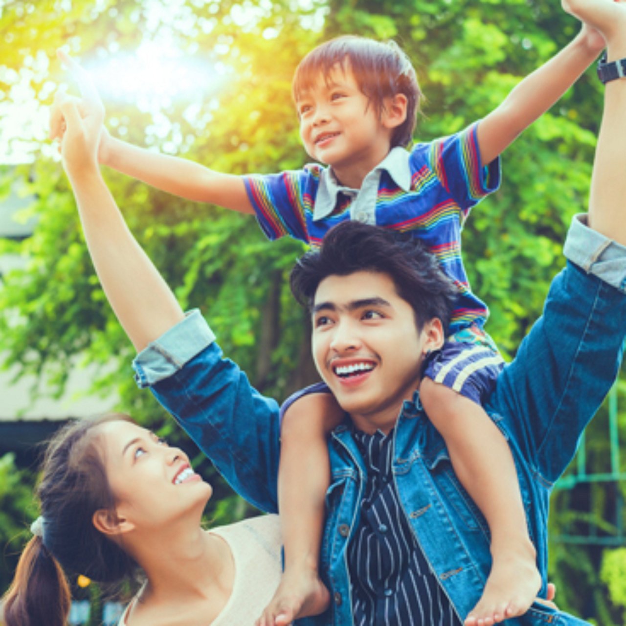 Family outdoors. Father carrying son on his shoulders