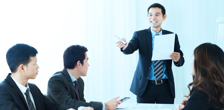 One man in a suit presenting to another
