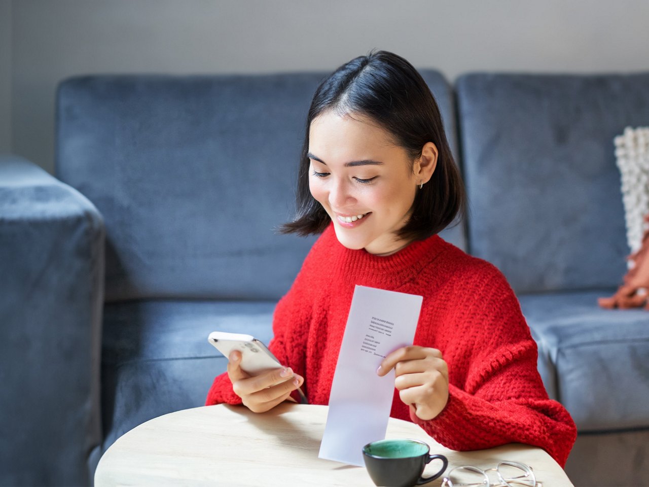 A smiling woman holding her phone.