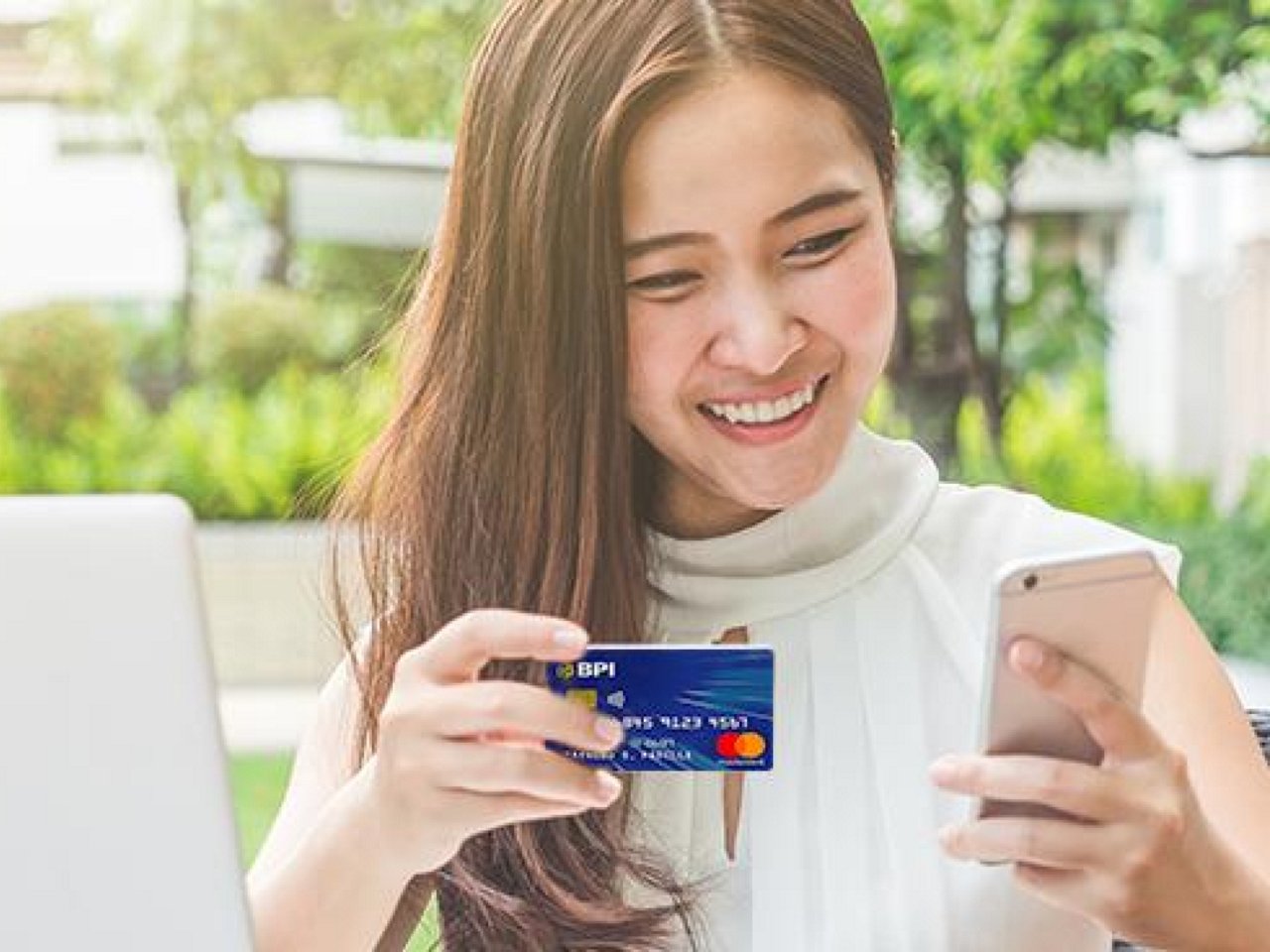 A smiling woman holding her card.