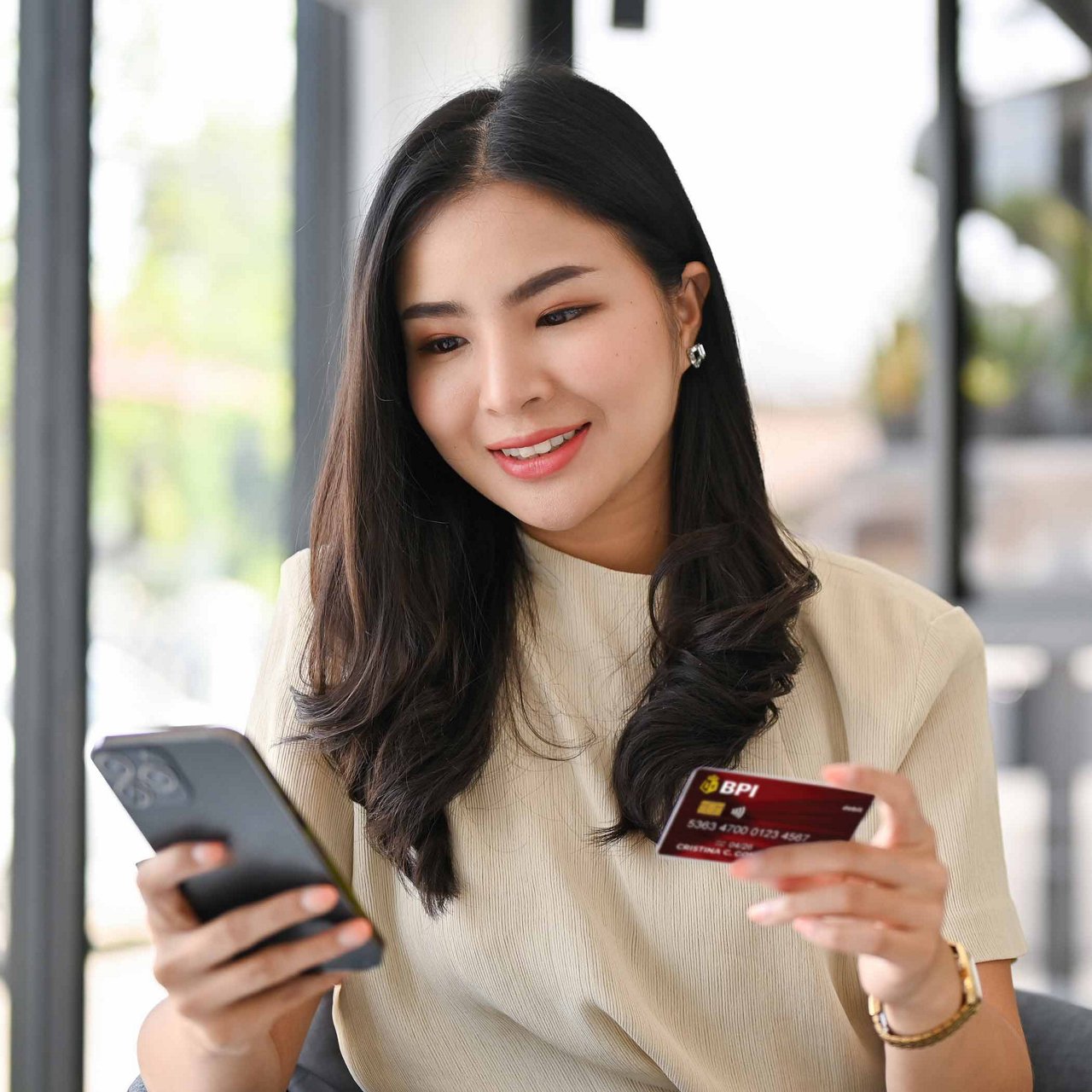 A woman holding her phone and card.