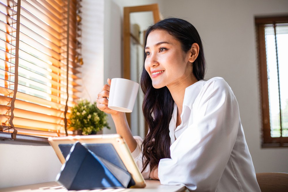 A woman with coffee on one hand inside a café.