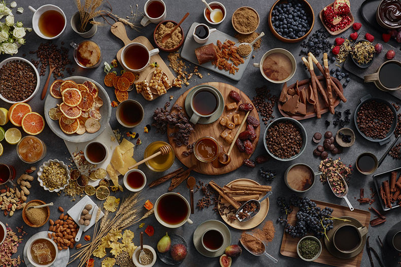 테이블위에 다양한 커피원두와 과일들, 여러가지 향신료들이 놓여져 있다.