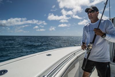 Fisherman Nick Milford standing on a boat with a fishing line