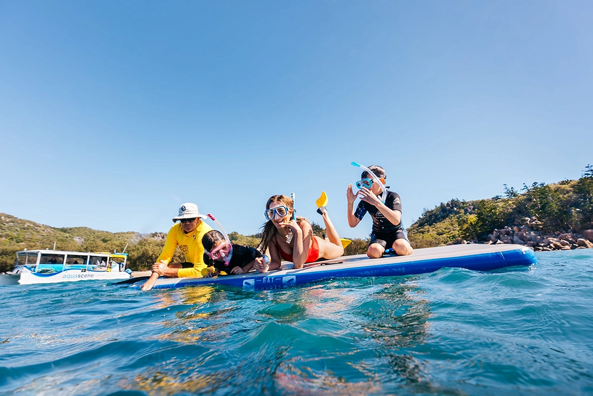 A family on a small boat wearing snorkelling gear on Magnetic Island A family on a small boat wearing snorkelling gear on Magnetic Island