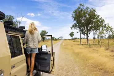Women leans out of 4WD along Capricorn Way, with views of the Central Highlands outside of Emerald