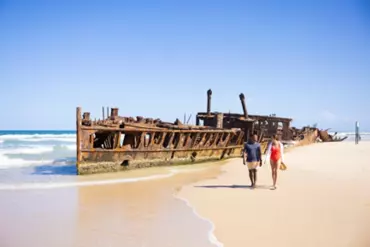 Couple walking along the beach past the historic SS Maheno shipwreck | 48 hours on K'gari (formerly Fraser Island)