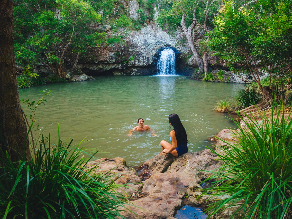 Couple having a swim in the rock pool at Kondalilla Falls Couple having a swim in the rock pool at Kondalilla Falls