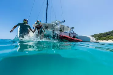 Couple jumping into the water to snorkel, while on a Whitehaven & Chalkies Beach cruise with Explore Group | Great Barrier Reef tours Couple jumping into the water to snorkel, while on a Whitehaven & Chalkies Beach cruise with Explore Group | Great Barrier Reef tours