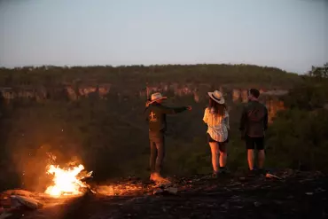 Indigenous guide and guests next to the campfire in remote Cape York, on Jarramali Rock Art Tours Indigenous guide and guests next to the campfire in remote Cape York, on Jarramali Rock Art Tours